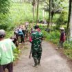 Foto: Babinsa Koramil 0806-04/Bendungan bersama warga melaksanakan karya bakti membersihkan material tanah longsor dan saluran air di Dusun Soko, Desa Depok, Kecamatan Bendungan, Kabupaten Trenggalek, Minggu (11/1/2026)