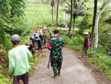 Foto: Babinsa Koramil 0806-04/Bendungan bersama warga melaksanakan karya bakti membersihkan material tanah longsor dan saluran air di Dusun Soko, Desa Depok, Kecamatan Bendungan, Kabupaten Trenggalek, Minggu (11/1/2026)