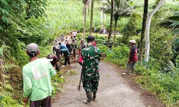 Foto: Babinsa Koramil 0806-04/Bendungan bersama warga melaksanakan karya bakti membersihkan material tanah longsor dan saluran air di Dusun Soko, Desa Depok, Kecamatan Bendungan, Kabupaten Trenggalek, Minggu (11/1/2026)