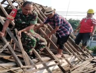 Foto: Seorang Babinsa bersama warga bergotong royong memperbaiki atap rumah milik Djumiati, warga Kelurahan Bendogrit, Kecamatan Sananwetan, Kota Blitar, Minggu (18/1/2026)