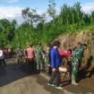 Foto: Personel TNI dari Koramil 0806-04/Bendungan bersama warga Desa Masaran bergotong royong membersihkan saluran air dan material tanah di tepi jalan desa, Kecamatan Bendungan, Kabupaten Trenggalek, Jumat (16/1/2026)