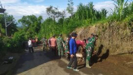 Foto: Personel TNI dari Koramil 0806-04/Bendungan bersama warga Desa Masaran bergotong royong membersihkan saluran air dan material tanah di tepi jalan desa, Kecamatan Bendungan, Kabupaten Trenggalek, Jumat (16/1/2026)