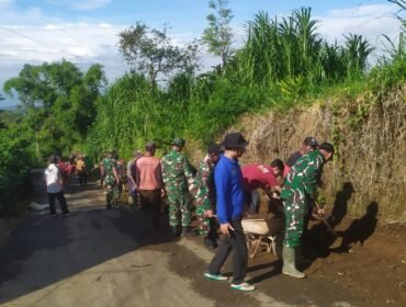 Foto: Personel TNI dari Koramil 0806-04/Bendungan bersama warga Desa Masaran bergotong royong membersihkan saluran air dan material tanah di tepi jalan desa, Kecamatan Bendungan, Kabupaten Trenggalek, Jumat (16/1/2026)