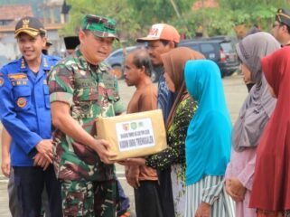 Foto: Seorang prajurit TNI menyerahkan bantuan sosial kepada warga dalam rangka kegiatan TMMD ke-128 Kodim 0806/Trenggalek di Desa Sukorejo, Kecamatan Gandusari, Rabu (22/4/2026).