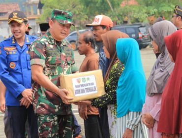 Foto: Seorang prajurit TNI menyerahkan bantuan sosial kepada warga dalam rangka kegiatan TMMD ke-128 Kodim 0806/Trenggalek di Desa Sukorejo, Kecamatan Gandusari, Rabu (22/4/2026).