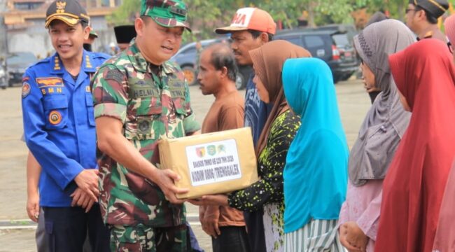 Foto: Seorang prajurit TNI menyerahkan bantuan sosial kepada warga dalam rangka kegiatan TMMD ke-128 Kodim 0806/Trenggalek di Desa Sukorejo, Kecamatan Gandusari, Rabu (22/4/2026).