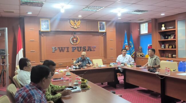 Foto: Ketua Tim Penyelaras Anrico Pasaribu menyerahkan naskah final AD/ART, Kode Etik Jurnalistik (KEJ), dan Kode Perilaku Wartawan (KPW) kepada Ketua Umum Akhmad Munir, disaksikan jajaran pengurus dalam rapat pleno PWI Pusat di Jakarta, Senin (4/5/2026).