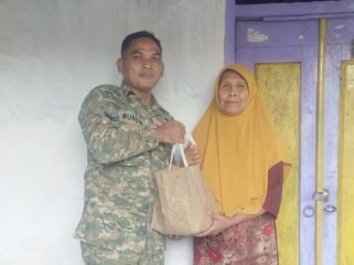 Foto: Seorang prajurit TNI AD, Sertu Nurdin, menyerahkan bantuan sembako kepada warga lanjut usia di Desa Dagangan, Kecamatan Dagangan, Kabupaten Madiun, Minggu (31/5/2026)