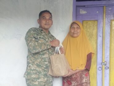 Foto: Seorang prajurit TNI AD, Sertu Nurdin, menyerahkan bantuan sembako kepada warga lanjut usia di Desa Dagangan, Kecamatan Dagangan, Kabupaten Madiun, Minggu (31/5/2026)