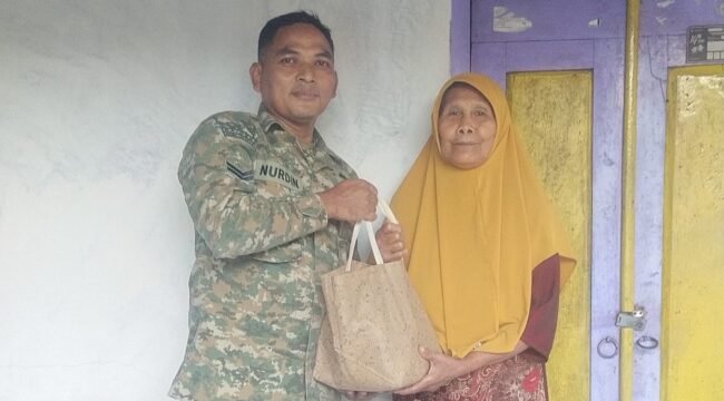Foto: Seorang prajurit TNI AD, Sertu Nurdin, menyerahkan bantuan sembako kepada warga lanjut usia di Desa Dagangan, Kecamatan Dagangan, Kabupaten Madiun, Minggu (31/5/2026)