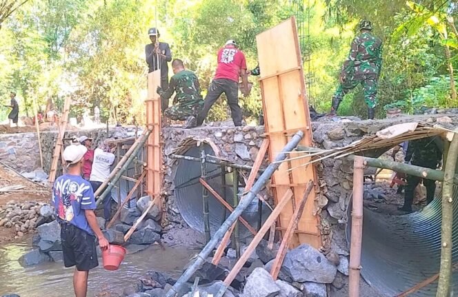 
					Foto: Personel TNI bersama warga bergotong royong mengerjakan pembangunan Jembatan Garuda di salah satu lokasi sasaran di Kabupaten Ponorogo, Selasa (23/6/2026).